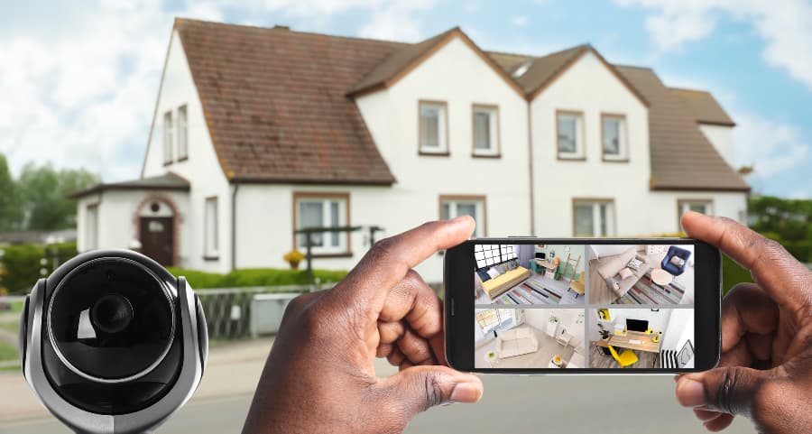 Man holding mobile device and looking at footage from video cameras